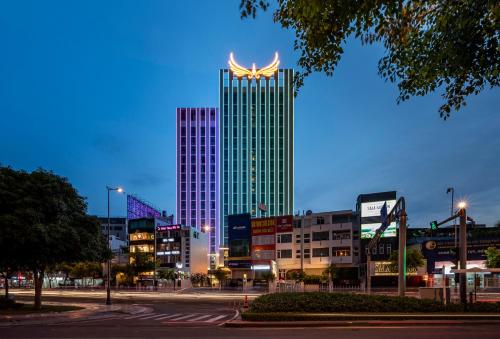 ホーチミン・シティにあるMuong Thanh Luxury Saigon Hotelの看板が上がる高層ビル