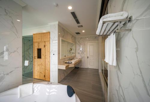 a bathroom with a tub and a sink at Muong Thanh Luxury Saigon Hotel in Ho Chi Minh City