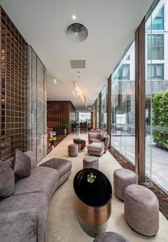 a living room with a couch and chairs and a table at Muong Thanh Luxury Saigon Hotel in Ho Chi Minh City