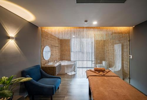a bedroom with a large bed and a bathroom with a tub at Muong Thanh Luxury Saigon Hotel in Ho Chi Minh City