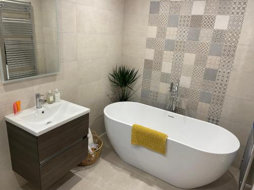 a bathroom with a white tub and a sink at Beautiful private room and bathroom in Ballycastle