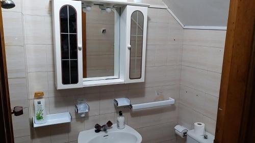 uma casa de banho com um lavatório, um espelho e um WC. em Casa con Piscina en Ramiras, Ourense em Santo Tomé