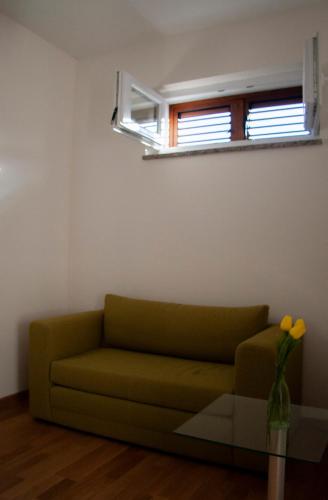 a green couch in a living room with a window at Vila Casa di mare Jelsa, otok Hvar in Jelsa