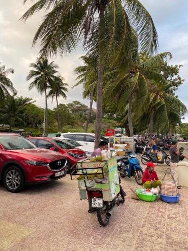 a man riding a motorcycle with a cart on the back at Paradise Condotel Mũi Né - Căn hộ nghỉ dưỡng Ocean Vista in Ấp Ngọc Hải