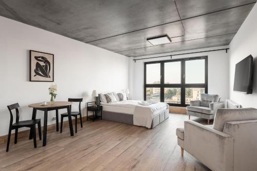 a bedroom with a bed and a table and a couch at Apartamenty Przystanek Morska in Gdynia