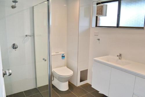 a white bathroom with a toilet and a sink at Cameo Court 2 in South West Rocks