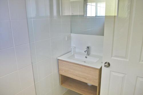 a white bathroom with a sink and a mirror at Carrington 6 in South West Rocks