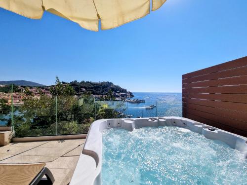 a hot tub on a patio with a view of the ocean at Hotel Plaza in Porto Azzurro