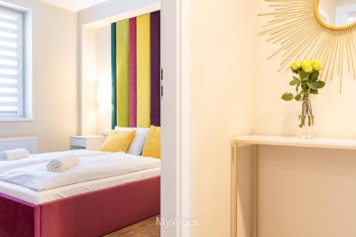 Pokój z łóżkiem i wazą kwiatów w obiekcie Apartamenty Na Szlaku, MyWeek w Kłodzku