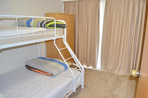 a bunk bed in a room with a window at Woody Wonder in South West Rocks