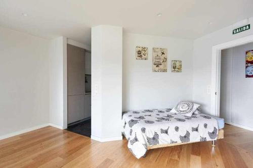 1 dormitorio blanco con 1 cama y suelo de madera en Apartamento Singular Deluxe, en Pamplona