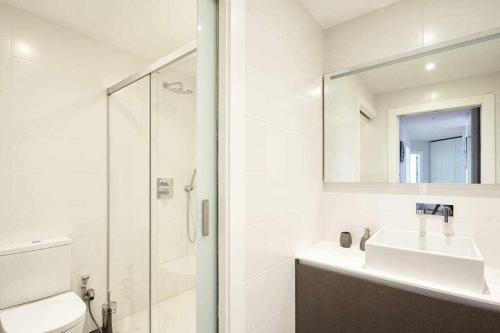 y baño blanco con lavabo y ducha. en Apartamento Singular Deluxe, en Pamplona