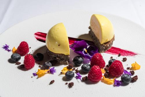 a piece of cheesecake with berries on a white plate at Heritage Hotel Kukuriku in Kastav