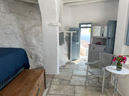 a bedroom with a bed and a table and chairs at Windhouses Serifos in Serifos Chora