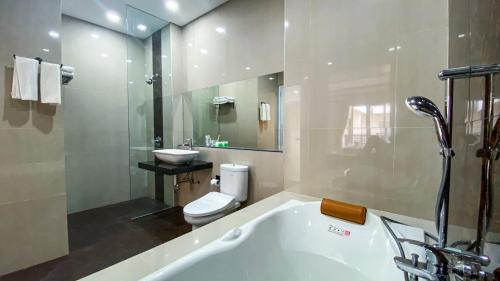 a bathroom with a tub and a toilet and a sink at Ultimate Residence Bali in Denpasar