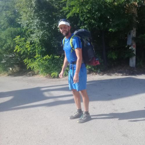 a man with a backpack standing in the road at Akhaltsikhe hotel “Sunny House” in Akhaltsikhe