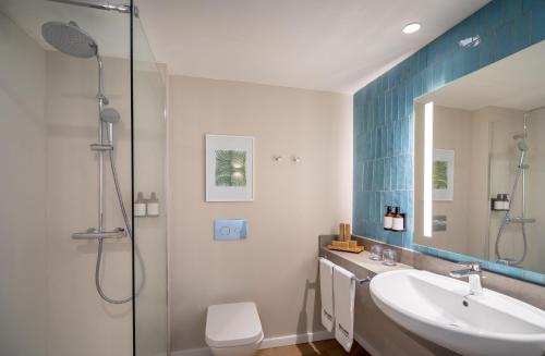 a bathroom with a sink and a shower and a toilet at Barceló Aguamarina in Cala d´Or
