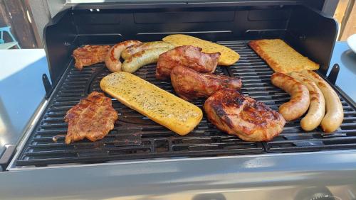 a grill with different types of meat and sausages at Appartement STOA in Kleinarl