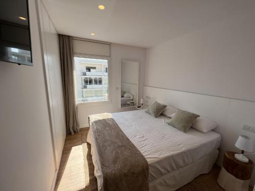 a bedroom with a white bed and a window at Alexandra 29 in Roses