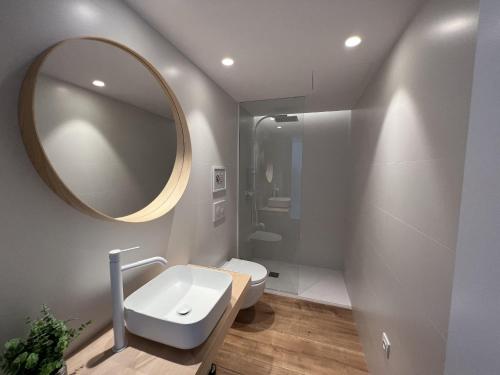 a bathroom with a white toilet and a mirror at Alexandra 29 in Roses