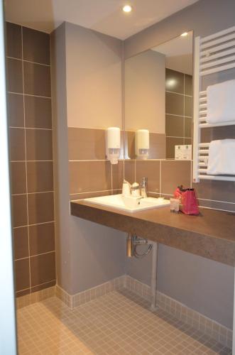 a bathroom with a sink and a mirror at EastLodge Lyon Est Eurexpo in Saint-Priest