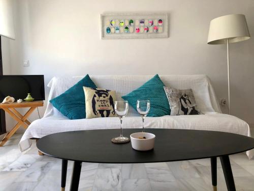 a living room with a couch and a table with wine glasses at The funny Tuna in Zahara de los Atunes