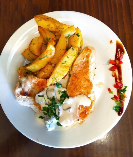 a plate of food with fish and potatoes on a table at Hotel Mara in Baia Mare