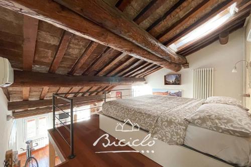 a bedroom with a bed in a room with wooden ceilings at Biciclo' Ferrara Città in Ferrara