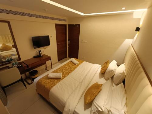 a hotel room with a large bed and a desk at The Kings Park Grand-Near US Consulate in Chennai
