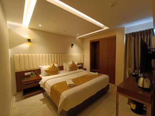 a hotel room with a large bed and a television at The Kings Park Grand-Near US Consulate in Chennai