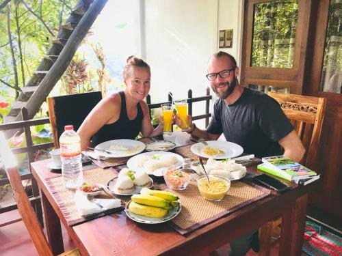 a man and woman sitting at a table with food at Ella Sandy Heaven Homestay in Ella