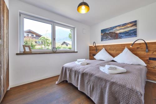 een slaapkamer met een bed met twee handdoeken erop bij Sunshine Apartment Spirit of Deer in Garmisch-Partenkirchen
