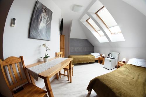 a room with two beds and a table in it at Pokoje Zygmuntowska in Nowy Sącz