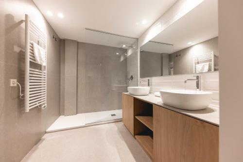 ein Badezimmer mit zwei Waschbecken und einem großen Spiegel in der Unterkunft Bravissimo Sirenes, 2-bedroom apartment in Girona