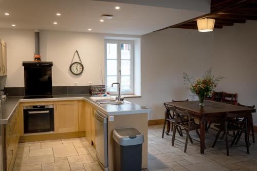 eine Küche und ein Esszimmer mit einem Tisch und einem Waschbecken in der Unterkunft gîte du château in La Bussière