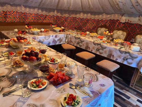une longue table avec des assiettes de nourriture dans l'établissement Guesthouse Damira, à Kyzyloy