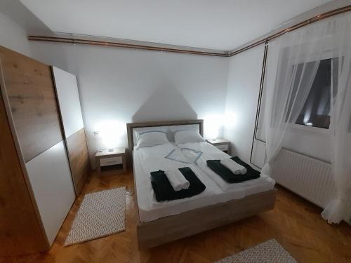 a bedroom with a bed with two pillows and a window at Apartman Stevan in Pirot