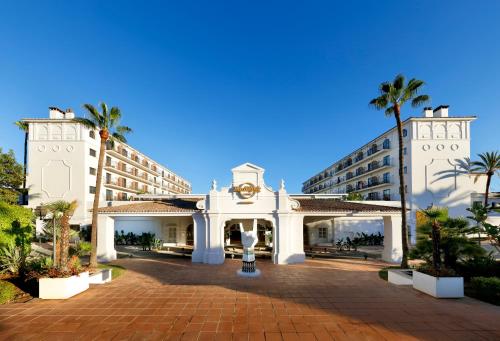a large white building with palm trees at Hard Rock Hotel Marbella - Adults Only Recommended in Marbella