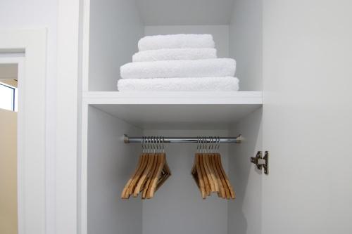 a white towel rack with towels in a bathroom at Phaedrus Living - Seaside Luxury Flat Harbour 109 in Paphos