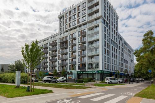 a large white building on a city street at Warsaw Ursynów Apartment with Balcony by Noclegi Renters in Warsaw