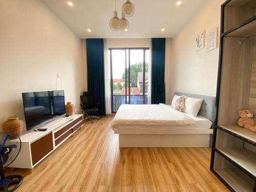 a bedroom with a bed and a flat screen tv at VILLADECELIA in Da Lat
