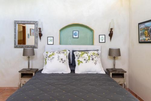 1 dormitorio con 1 cama con 2 lámparas y espejo en Antria Boutique Lodge, en Blenheim