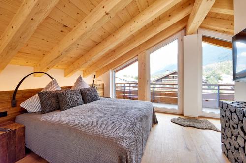 a bedroom with a bed and large windows at Chalet Sunshine in Garmisch-Partenkirchen
