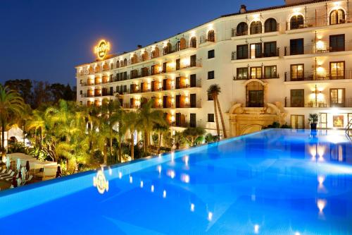 a large blue swimming pool in front of a hotel at Hard Rock Hotel Marbella - Puerto Banús in Marbella