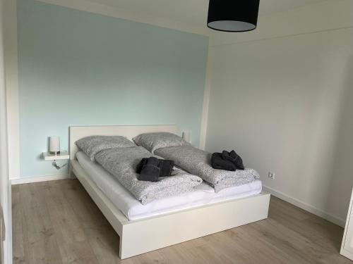 een witte kamer met een bed met grijze dekens bij Ferienwohnung Allenberg-Panorama in Winterberg