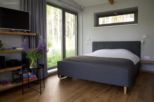 1 dormitorio con cama y ventana grande en Brīvdienu māja Empagi, en Lādezers