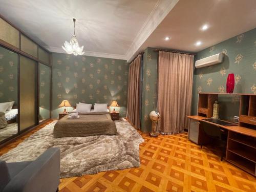 a bedroom with a large bed and a desk at Old City Lux in Baku