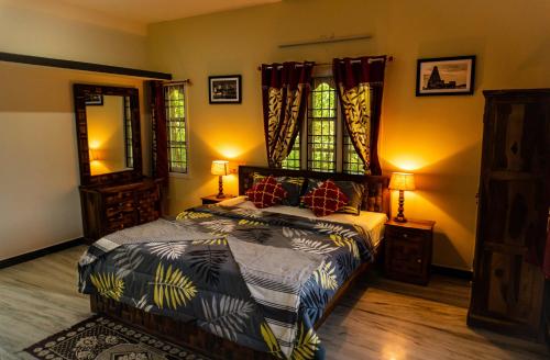 1 dormitorio con 1 cama, 2 lámparas y espejo en The Mahizh Home, en Mahabalipuram