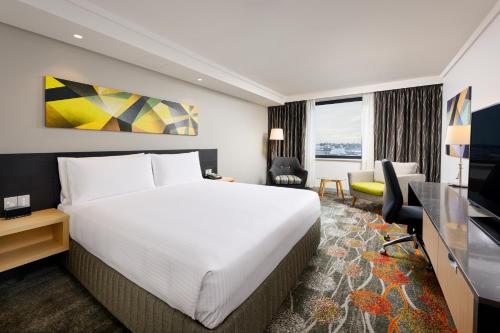 Pokój hotelowy z łóżkiem i biurkiem w obiekcie Holiday Inn Perth City Centre, an IHG Hotel w mieście Perth
