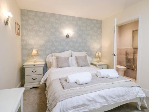 a bedroom with a large bed with two pillows on it at Churn Dash Cottage in Denby